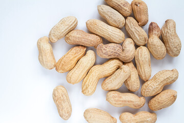Peanuts (Monkey nuts), unpeeled, in their hard shells. Nuts flat lay composition on a white...