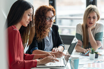 Group of multiage designer women working in a design project while choosing materials in the office.