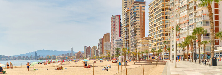 Beach of Benidorm at sunny summer day, city skyline horizontal background. Modern skyscrapers seaside and seafront view. Costa Blanca, Province of Alicante. Spain