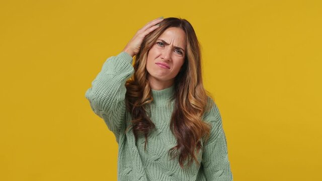Tired young brunette woman 30s years old wears mint sweater did not get enough sleep last night after party and barely got up in the morning yawning solated on plain yellow background studio portrait