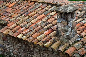 The roof of old house is covered with clay tiles with chimney Background texture