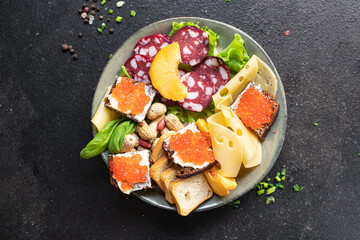 snack plate antipasto caviar, sausage, meat, cheese, nuts, peach, fruit, toast bread appetizers meal snack antipasti on the table copy space food background