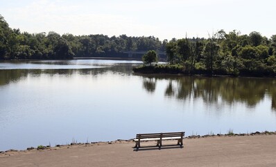 Obraz premium The empty park bench with a view of the lake.