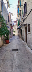 Fototapeta na wymiar View of a narrow street and stone houses. Historic City of Trogir. Dalmatia. Croatia. Europe 