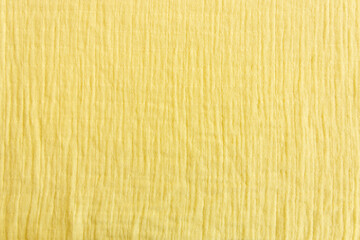 Soft muslin fabrics, baby blanket background. Cotton clothing and textiles. Natural organic fabrics texture. Light yellow, , lemon color. Close up. Top view - obrazy, fototapety, plakaty