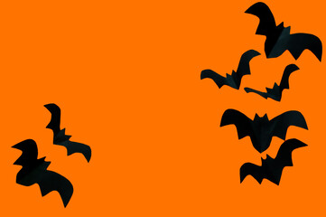 Halloween concept, black paper bats on an orange background. High quality photo