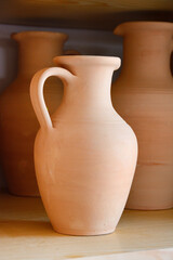 Ceramic craft jug made by a Potter, against the background of other clay products