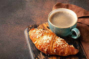 Cup of coffee and fresh croissant