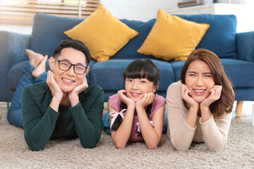 Relax Asian family laying with happy and smile on carpet in living room at home...