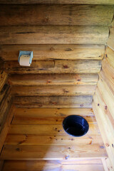 wooden village toilet with a hole in the floor and toilet paper