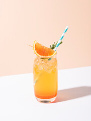 Cold and refreshing orange punch cocktail with orange slice on yellow background. summer drink.