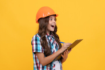 surprised teen girl in construction helmet making notes in clipboard, check results