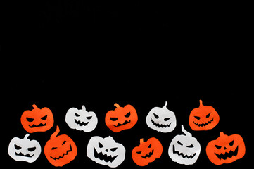 neloween, paper pumpkins orange and white on a black background, isolated. High quality photo