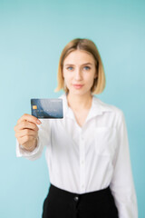 Bank credit. Female officer. Loan rate. Online payments. Best proposition. Happy official woman holding plastic card in hand isolated blue.