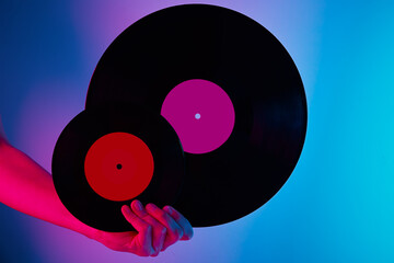 Woman hold two retro vinyl disc in hands, toned photo. Vintage style 80s and 90s years