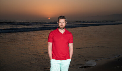 cheerful man over the sea on sunsdown summer beach, vacation