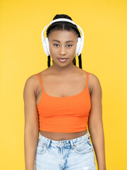Music device. Audio track. Stereo sound. Millennial Afro woman in earphones listening song playlist isolated on orange background.