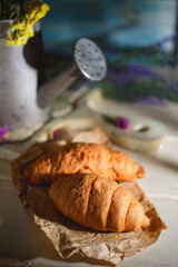 Provence still life with French croissants, rustic watering can and lavender flowers