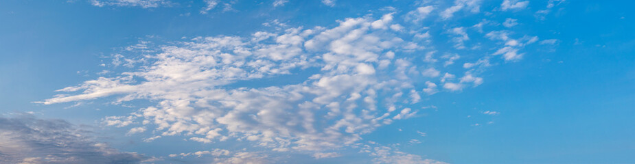 Panorama of blue sky with white air clouds. Banner.