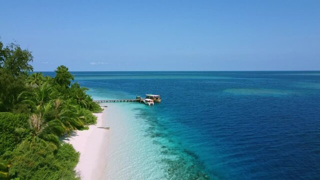 Bird's-eye view of a tropical beach. Top view of the blue beach at sunset. Beautiful beach with white sand at sunset. A bird's-eye view of a tropical beach, sea waves smoothly roll over a beautiful co
