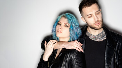 Cyberpunk style. Hipster couple. Fashion model shooting. Rock party. Confident man and woman leather jacket posing embracing together isolated white copy space.