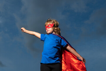 Fototapeta na wymiar Child in super man cloak. Boy playing superhero. Success and kids winner concept.