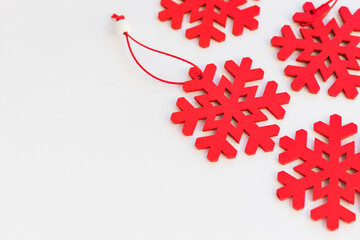 Bright red wooden snowflakes on white background. Christmas and new year decorations. Winter ornament, seasonal decor. Top view.