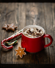 Hot chocolate with marshmallows in the red cup on the wooden cutting board. High quality photo