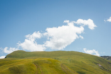 paysage d'une colline verte et d'un ciel bleu. une montagne de gazon et un nuage blanc