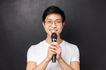Leisure, people and music concept. Portrait of cute smiling asian man in white t-shirt, holding...