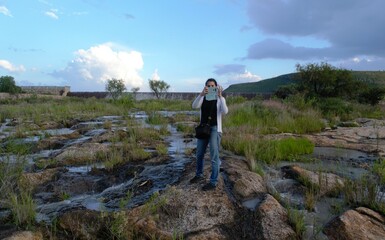 Mujer con un celular toma una fotografía a la naturaleza