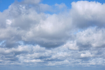 Fototapeta na wymiar Cumulus clouds against blue sky, background of the copy space