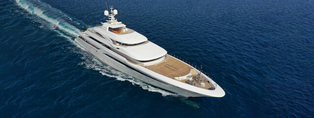 Aerial drone ultra wide panoramic photo of super yacht cruising deep blue Aegean sea near famous...