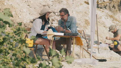 Archaeologists analyzing fossils under tent