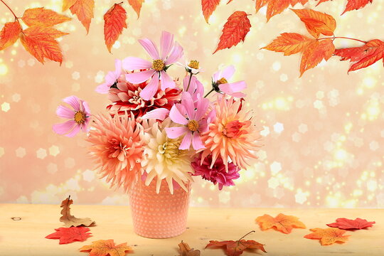 Dahlias and daisies in a vase on a blurred bokeh background.Autumn abstract composition, thanksgiving day concept, seasonal background, banner or splash, greeting card or invitation 