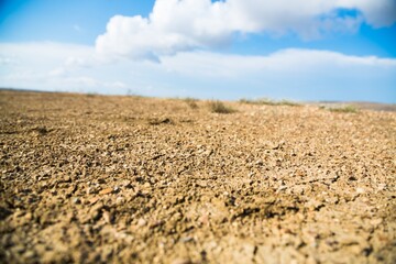 The dry ground is cracked and blue sky