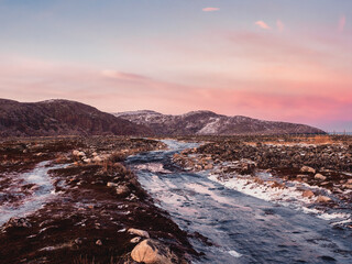 Obraz premium An impassable icy road through the winter tundra. A rough, rocky road stretching away into the distance. Kola Peninsula.