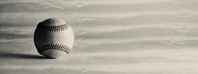Old monochrome grunge texture background with used game ball from baseball sport.