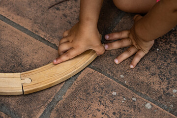 Wooden toy road. A kid is playing with a puzzle road made in wood. Outdoor stem education with playful toy