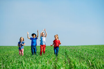 Running kids in green field during summer.