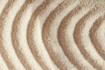 Fototapeta na wymiar Quartz sand.Round waves on sand.