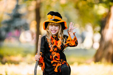Happy Halloween. Cute little witch smiling