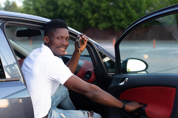 An African-American man holds a car key in his hands. Buying and renting a car