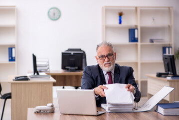 Old male employee working in the office