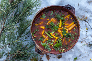 Meat soup "Chili con carne" cooked in a cauldron outdoors in winter