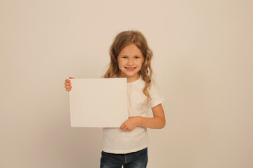 a beautiful sweet happy girl with long hair in a white T-shirt is holding a white sheet in her hands