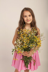 portrait of a beautiful long-haired girl with wild autumn wildflowers in her hands