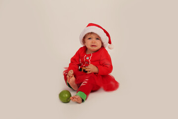 beautiful little girl in a Christmas costume and santa hat on a white background