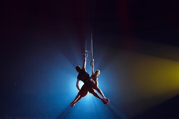 Circus actress acrobat performance. Two boys perform acrobatic elements in the air.