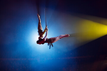 Circus actress acrobat performance. Two boys perform acrobatic elements in the air.